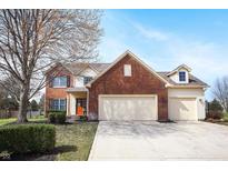 Charming two-story home featuring a brick facade, attached two-car garage, and well-manicured lawn at 18358 Benton Oak Dr, Noblesville, IN 46062