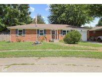 Charming brick ranch-style home with a well-manicured lawn, blue shutters, and an American flag at 1906 E Markwood Ave, Indianapolis, IN 46227