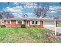 Charming brick ranch-style home with manicured lawn and mature trees, offering classic curb appeal and a welcoming atmosphere at 2632 W 40Th St, Anderson, IN 46011