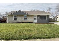 Charming single-story home featuring a well-maintained lawn and a stone and vinyl exterior at 2638 Calbert Dr, Indianapolis, IN 46219