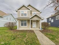 Charming two-story home featuring a covered front porch, tidy landscaping, and neutral siding at 2918 Wade St, Indianapolis, IN 46203