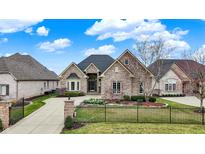 Charming brick home featuring a meticulously landscaped front yard and a private gated entrance at 4703 River Ridge Dr, Indianapolis, IN 46240