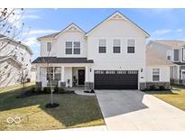 Inviting two-story home with a black two car garage, covered front porch, and manicured lawn at 5481 Noble Crossing W Pkwy, Noblesville, IN 46062