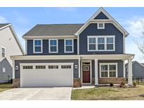 Charming two-story home featuring a two-car garage and attractive blue siding, set against a bright sky at 629 Washington St, Fortville, IN 46040