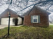 Charming single-Gathering brick home with a two-car garage and a well-maintained front lawn at 7399 Glendale Dr, Avon, IN 46123