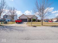 Charming single-story home with a brick facade, attached garage, and well-maintained lawn in a friendly neighborhood at 7404 Oak Mill Ct, Indianapolis, IN 46217