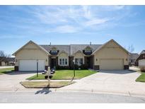 Charming townhome showcasing well-manicured lawn and attached garages, complete with inviting curb appeal at 946 Peppermill Run, Greenwood, IN 46143