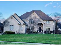 Elegant two-story brick home featuring a lush lawn, well-maintained landscaping, and an inviting entrance at 11967 Windpointe Pass, Carmel, IN 46033