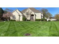 Beautiful brick home showcasing a well-manicured lawn and lush landscaping at 11967 Windpointe Pass, Carmel, IN 46033