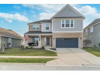 Beautiful two-story home featuring manicured lawn, covered porch with seating, and an attached two-car garage at 1283 Cliff View Dr, Westfield, IN 46074
