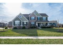 Inviting two-story home with a manicured lawn and a combination of brick and green siding at 2314 Angelina Way, Greenwood, IN 46143