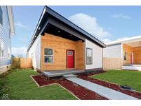 Beautiful modern home with wood and white paneling, black trim, a bright red door, and manicured lawn at 238 N Tacoma Ave, Indianapolis, IN 46201