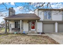 Charming two-story home with a red front door and a two-car garage nestled in a quiet neighborhood at 3051 Arrow Wood Ln, Indianapolis, IN 46214