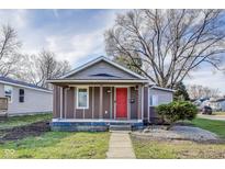 Charming single-story home featuring a bright red door and cozy front porch area with a neatly maintained yard at 4301 E 30Th St, Indianapolis, IN 46218