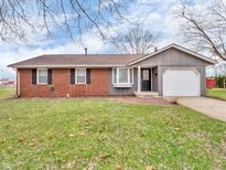 Charming single-story home featuring a brick facade, gray siding, and a well-maintained lawn at 611 Jackson St, Brownsburg, IN 46112