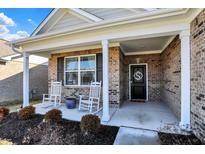 Inviting front porch with rocking chairs and a charming brick facade, perfect for relaxing outdoors at 6321 Stallion Way, Indianapolis, IN 46260