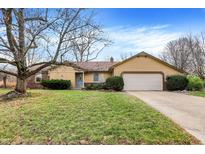 Charming single-story home featuring a well-manicured lawn, mature trees, and attached two car garage at 6501 Orville Ln, Indianapolis, IN 46237