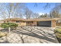 Charming single story brick home featuring a large two car garage and a well maintained yard at 8755 Guilford Ave, Indianapolis, IN 46240