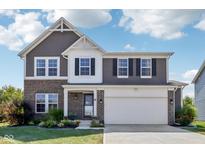 Charming two-story home featuring a brick and gray facade, with an attached two car garage and manicured front lawn at 9723 Violet Cir, Indianapolis, IN 46239
