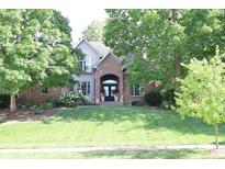 Beautiful home featuring a well-maintained lawn and mature trees providing shade at 9931 Woodlands Dr, Fishers, IN 46037