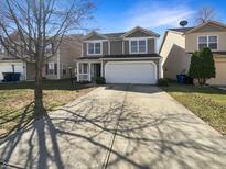 Charming two-story home with a well-manicured lawn and attached two-car garage at 10453 Apple Creek Dr, Indianapolis, IN 46235