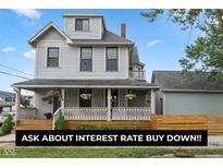 Charming two-story home with a welcoming front porch, beautiful landscaping, and attractive curb appeal at 1665 N College Ave, Indianapolis, IN 46202