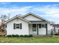 Charming single-story home with white siding, green trim, and a cozy front porch at 1840 S Cole St, Indianapolis, IN 46241