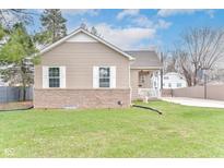 Charming home featuring a well-maintained lawn, complemented by white-framed windows and tan siding at 3147 Bonham Dr, Indianapolis, IN 46222