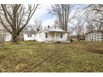 Charming single-story home with covered porch surrounded by mature trees and a large yard at 4355 W 450 S, Columbus, IN 47201