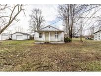 Charming single-story home with a covered porch and a detached garage nestled in a spacious yard at 4355 W 450 S, Columbus, IN 47201