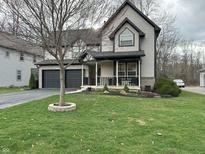 Charming two-story home featuring a well-manicured lawn and attached two-car garage at 5018 Melbourne Rd, Indianapolis, IN 46228