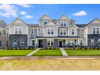 Charming townhome showcases brick accents, gray siding, and a well-manicured lawn under a bright, sunny sky at 5777 Cr W 750 N, McCordsville, IN 46055
