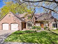 Charming brick home featuring a well-manicured lawn, mature trees and an attached two car garage at 6744 Robin Hood Ct, Indianapolis, IN 46227