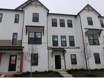 Charming townhome with white exterior, black trim, and manicured landscaping offers modern curb appeal at 7085 Pate Hollow Dr, Brownsburg, IN 46112