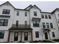 Modern townhome featuring a white exterior, black trim, and covered entrances with wood accents at 7089 Pate Hollow Dr, Brownsburg, IN 46112
