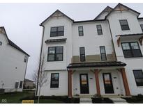 Modern townhome showcases a white facade with black accents and covered entrance at 7093 Pate Hollow Dr, Brownsburg, IN 46112