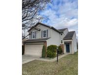 Charming two-story home with a manicured lawn and an attached two-car garage at 8033 Lake Tree Cir, Indianapolis, IN 46217