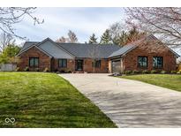 Charming single story brick home featuring a wide driveway and an attached garage at 8078 Sunfish Ct, Indianapolis, IN 46236