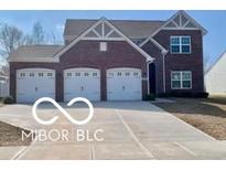Charming brick home featuring a three-car garage and well-manicured landscaping at 817 Capricorn Dr, Franklin, IN 46131