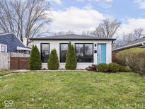Charming white brick home featuring a bright blue front door and manicured landscaping at 928 E Pleasant Run Parkway North Dr, Indianapolis, IN 46203