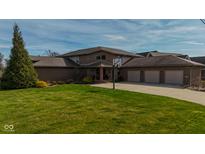 Beautiful brick home with a well-manicured lawn and three-car garage at 9398 W Mirror Rd, Columbus, IN 47201