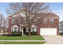 Charming two-story brick home featuring a well-manicured lawn and attached two-car garage at 9804 Hidden Hills Ln, Indianapolis, IN 46234