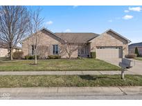Charming one-story brick home with an attached two-car garage and manicured front lawn at 1114 Woodridge, Brownsburg, IN 46112