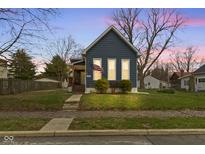Charming blue home featuring a neat front yard and well-lit windows at twilight at 1240 Wayne St, Noblesville, IN 46060