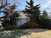 Charming single-Gathering home featuring mature trees, large windows, and a well-maintained lawn at 1635 N Lynhurst Dr, Indianapolis, IN 46224