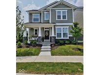 Charming two-story home with a covered front porch, stone accents, and professionally landscaped yard at 17301 Dallington St, Westfield, IN 46074
