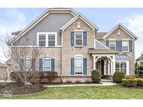Charming two-story home featuring brick facade, blue shutters, manicured lawn, and professionally landscaped yard at 209 North Bnd, Greenwood, IN 46142