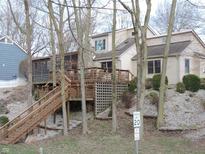 Back exterior of home featuring a large deck, access stairs and surrounding greenery at 269 Iron Bridge Rd, Cicero, IN 46034