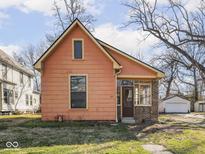 Charming, light orange home with a covered front porch and well-maintained lawn at 275 E Burgess Ave, Indianapolis, IN 46219