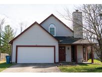 Charming two-story home featuring an attached garage, red trim, and covered front porch at 5867 Liberty Creek E Dr, Indianapolis, IN 46254
